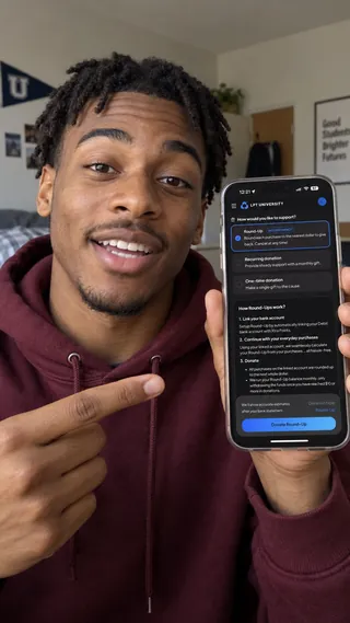 Ambassador content mockup of a student pointing to the giving screen in a dorm room.
