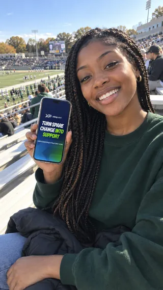 Ambassador content mockup of a student holding the XtraPoint page in the stadium bleachers.