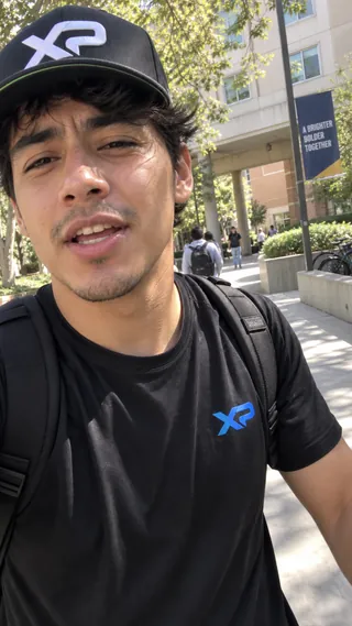 Ambassador content mockup of a student wearing an XtraPoint cap and shirt on a campus walk.