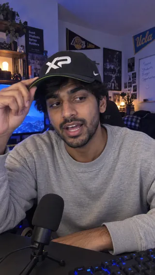 Ambassador content mockup of a student wearing an XtraPoint cap at a desk with a microphone.